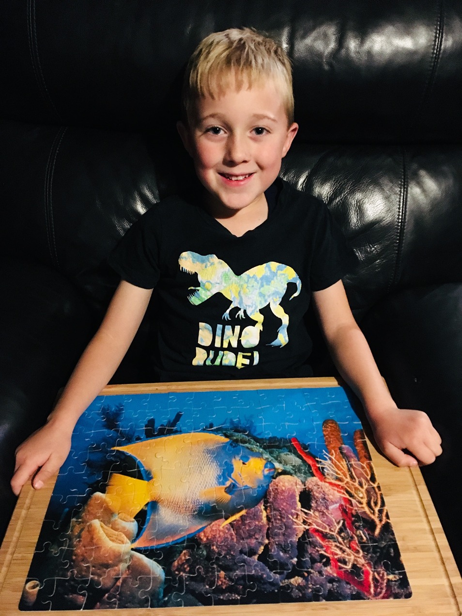 Child displaying the jigsaw puzzle they have completed