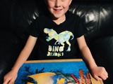 Child displaying the jigsaw puzzle they have completed
