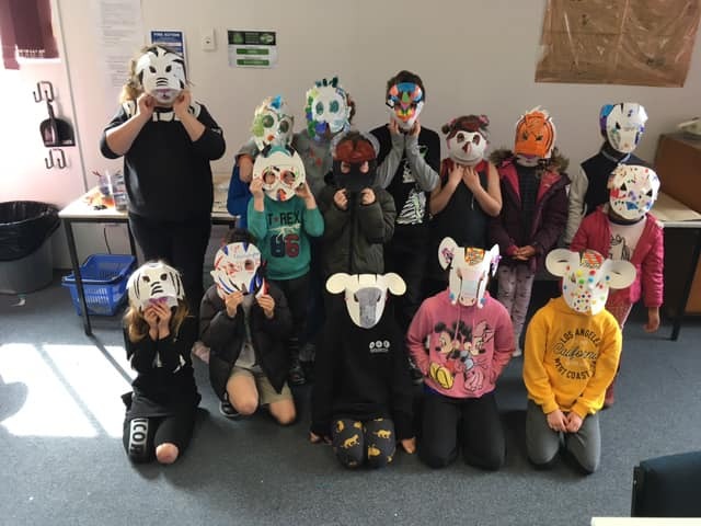 A group of children wearing animal themed masks they have created